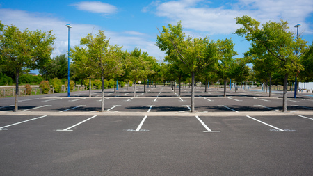 105410909-beautiful-empty-parking-lot-with-trees-on-sunny-summer-day-in-france1.jpg
